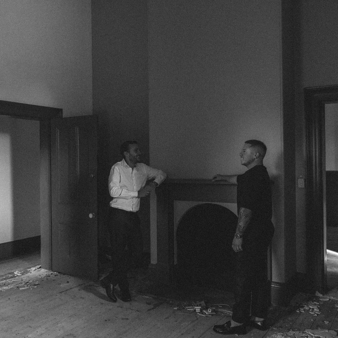 Two of the team talking by a fireplace in an unrenovated room